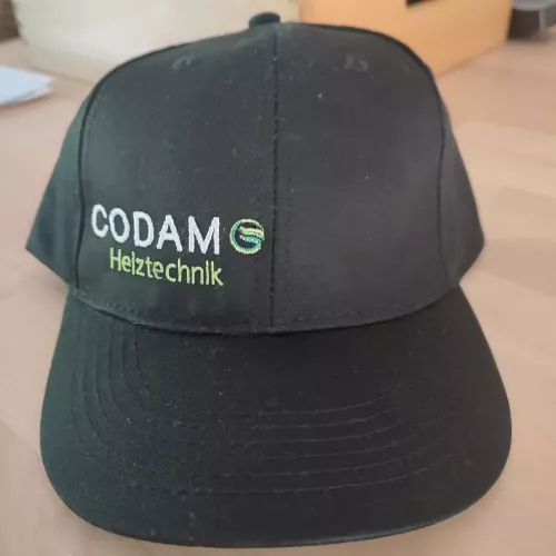 Firmenlogo Codamo Heiztechnik auf schwarzer Cap, gestickt mit Gunold Stickgarn