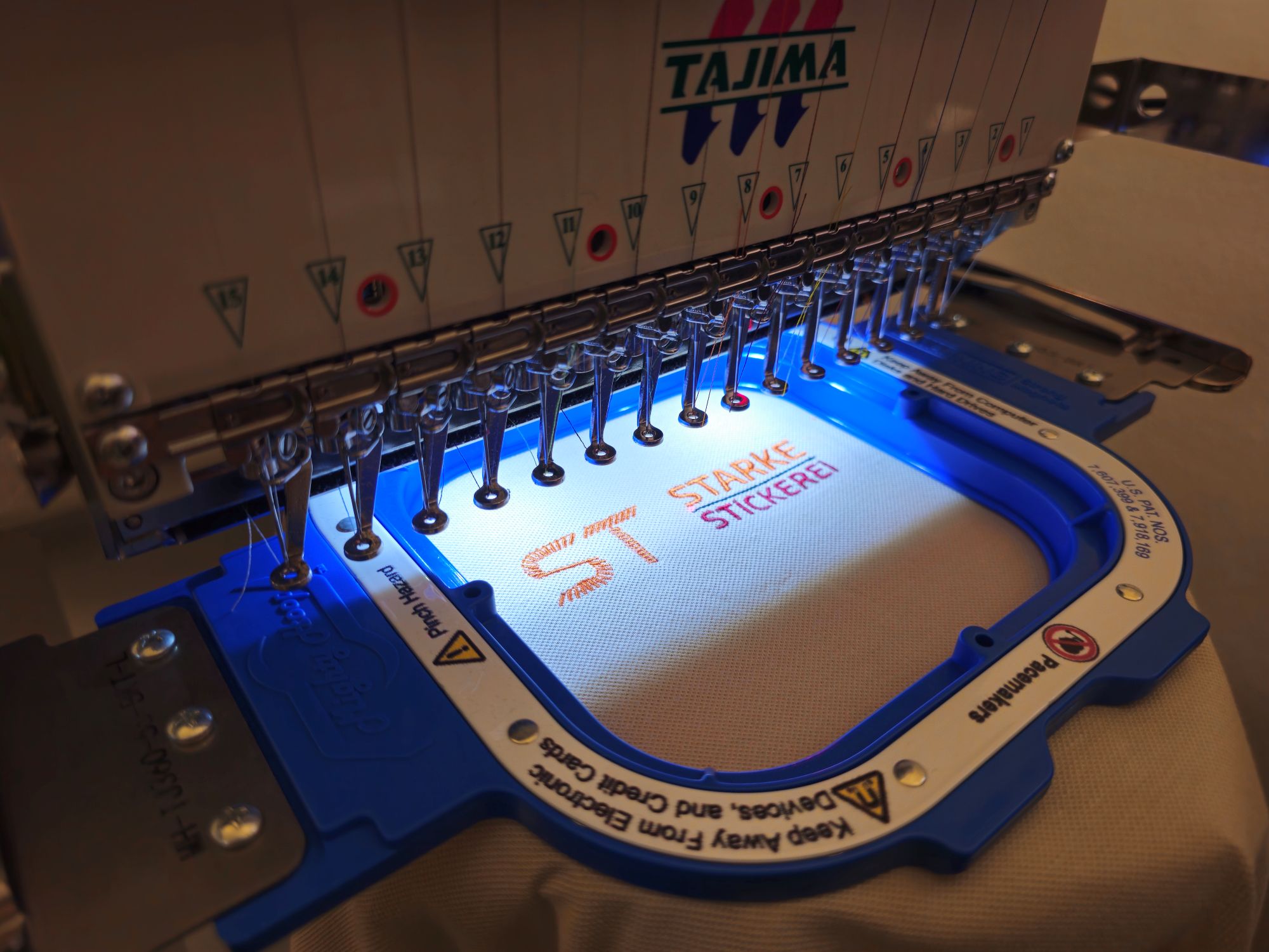 Tajima Stickmaschine während des stickens des Logos der Starke Stickerei